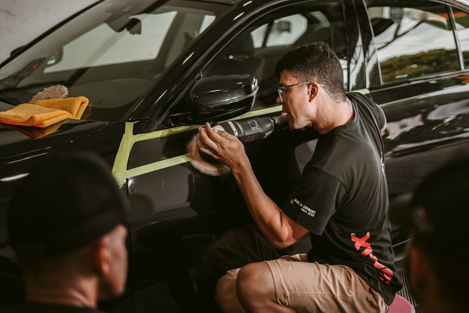 Professional auto detailer carefully working on a vehicle's exterior
